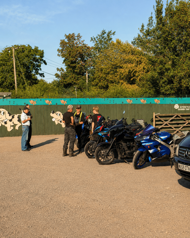 Visitors chatting beside a row of motorcycles during Buckovers Bike Night at Milbury Heath.